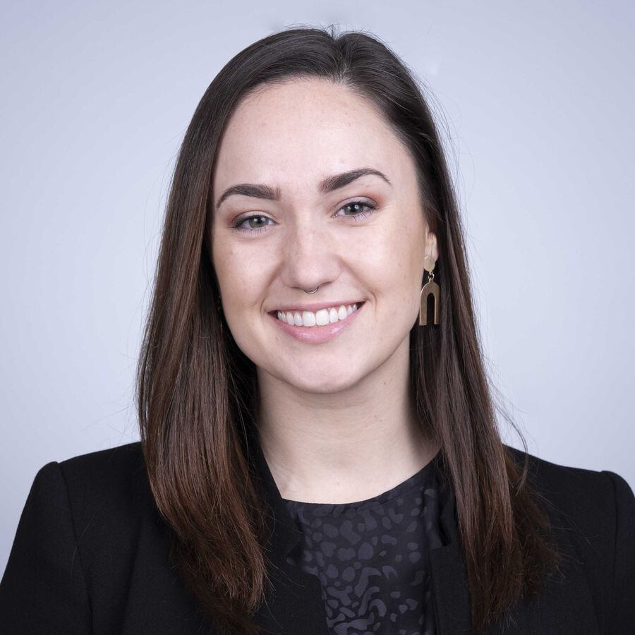 Professional headshot of a woman with long brown hair