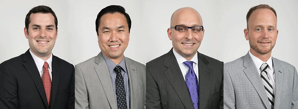 Team headshots in suits on a white backdrop