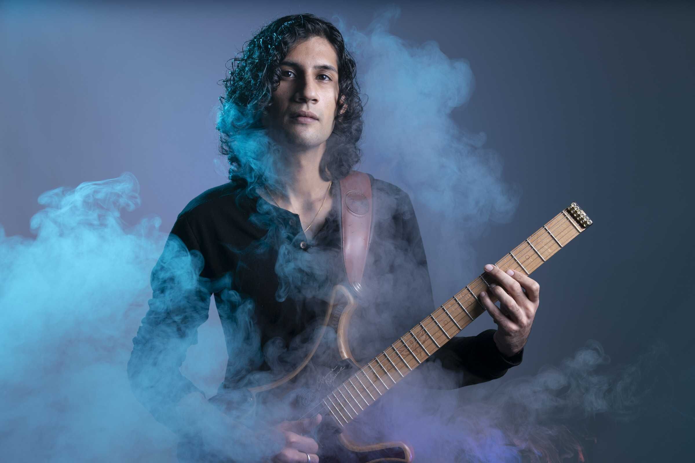 Guitarist surrounded by blue and purple smoke