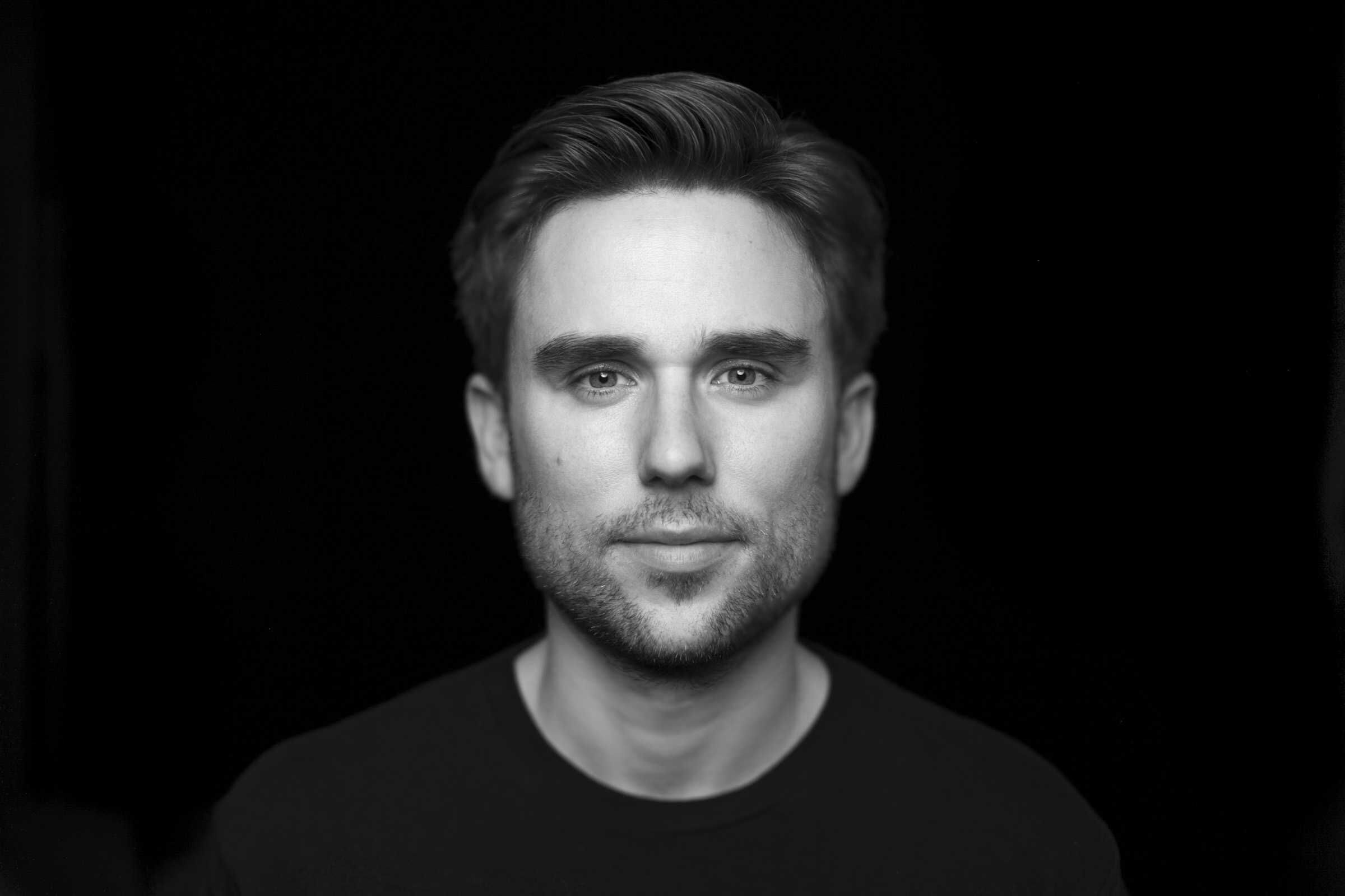 Black and white portrait of a man against a black background