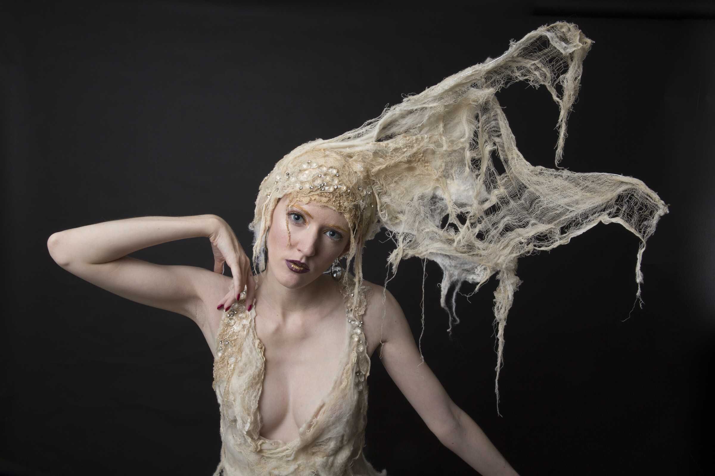 Model in a sculptural cream couture gown and headpiece